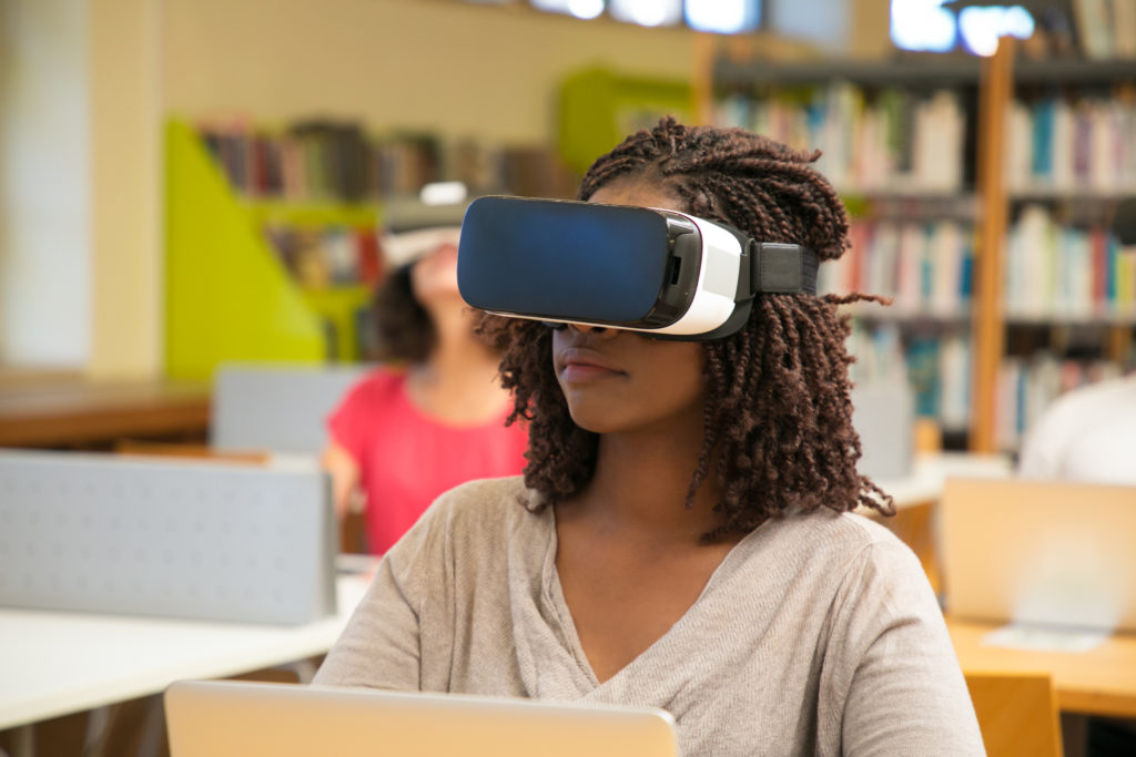 interracial group of students using vr experience for work