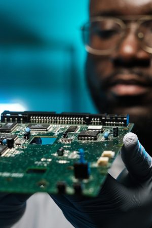 circuit board in gloved hands of young african laboratory worker